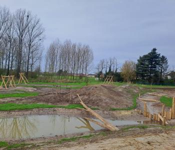 Het nieuwe speelterrein met slingerende wadi en aangelegde speelheuvels krijgt vorm